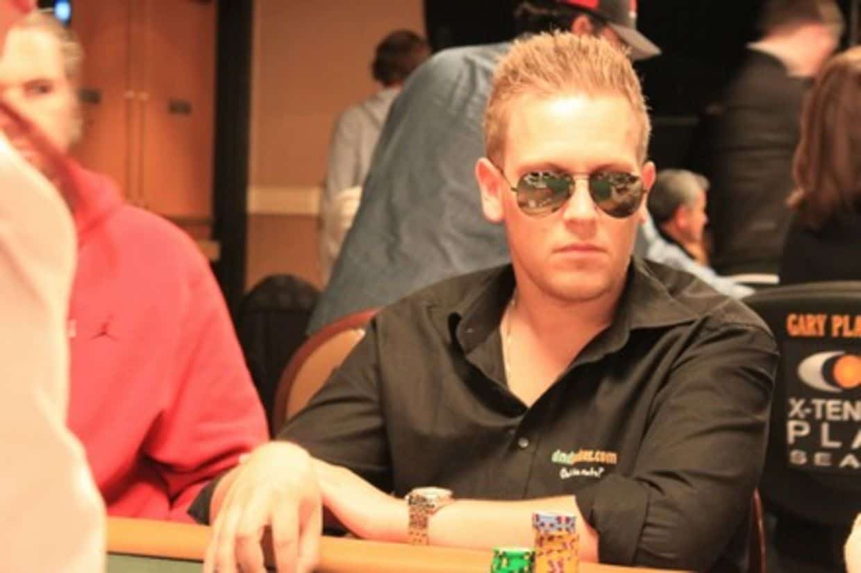 Danny in sunglasses and a black shirt seated at a live poker table.
